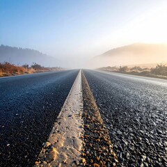 Empty road stretches into a hazy sunrise
