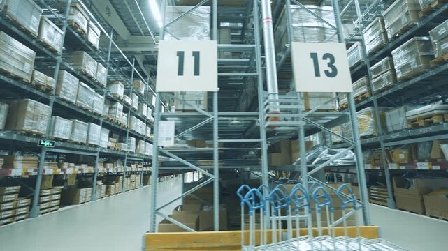 Long Aisle in Large Warehouse with High Shelves and Packed Cardboard Boxes
