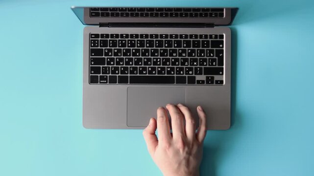 Person Using Laptop on Blue Background