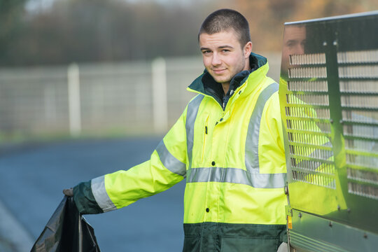 young waste collector with a garbage bin