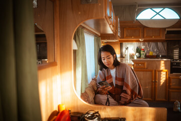 A woman takes pleasure in a serene and peaceful moment within a stylish camper interior