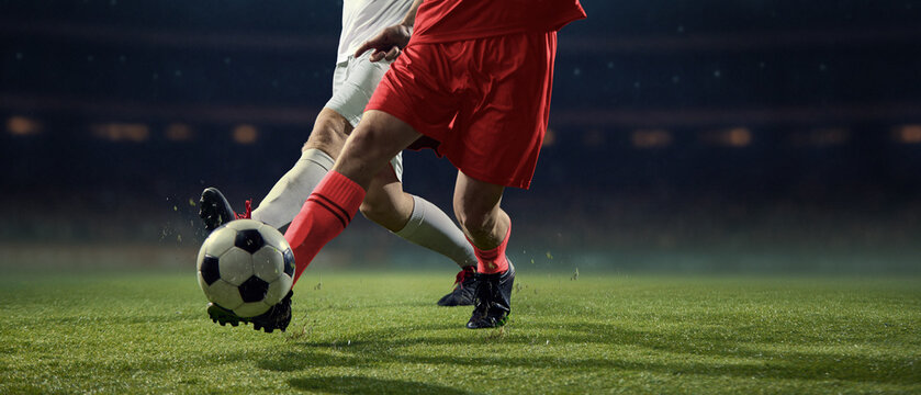 Aggressive football challenge between rival players near ball. Concept of high-stakes competition, struggle for victory, professional athleticism, competitive tension, match intensity.