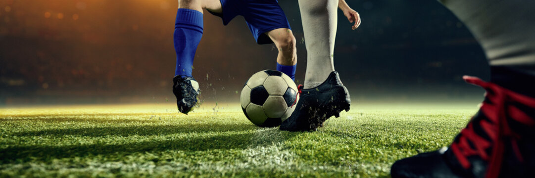Low angle football duel for ball dominance under pressure. Concept of high-stakes competition, struggle for victory, physical dominance, professional athleticism, competitive tension. Banner