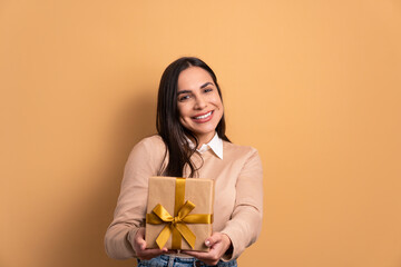 joyful brunette young woman giving gift box in studio shot. birthday, christmas, gift box concept.