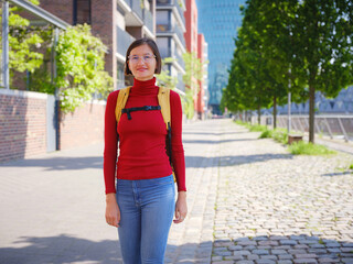 Tourist woman explores modern Frankfurt, walking through vibrant streets with contemporary architecture, skyscrapers, and urban spaces, enjoying lively atmosphere of modern side.