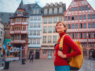Tourist woman strolls through old town of Frankfurt, exploring its historic streets, beautiful architecture, and cultural landmarks, enjoying vibrant atmosphere of citys past.