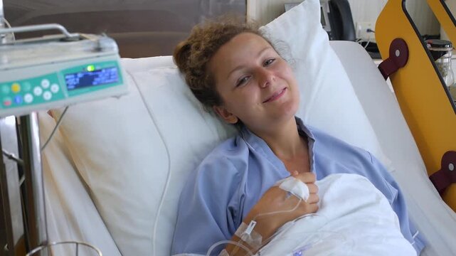 Positive young woman with an iv drip smiling and showing thumbs up and victory signs while recovering from illness or surgery, feeling optimistic about her successful treatment and healthcare