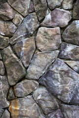 Uneven textured stone backdrop, Ancient rugged stone wall featuring moss and lichen growth