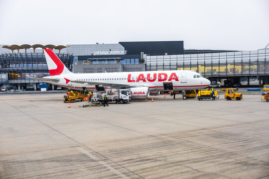 Vienna, Austria - 15 December, 2025: Lauda airline aircraft at Vienna International Airport. Ground crew and vehicles are present, showcasing airport operations and travel logistics.