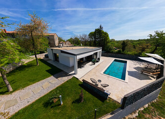 Aerial view of a modern modular house with flat roof, swimming pool, and patio. Contemporary...