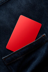 A vibrant red card peeks from a denim pocket, symbolizing style and practicality in everyday fashion.
