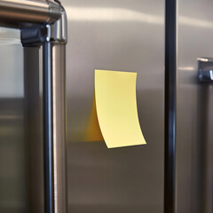 A vibrant yellow sticky note on a modern refrigerator, symbolizing reminders and organization in everyday life.