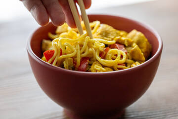 Close-Up of Curry Chicken Noodles in a Red Bowl
