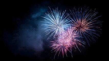 colorful fireworks bursting in night sky with blue, pink, and red starburst patterns

