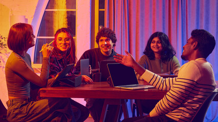 Creative group discussing project ideas in warm modern workspace. Concept of brainstorming, team communication, startup workflow, inclusive culture, and digital collaboration.