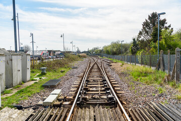 Points on railway tracks near a small train station on a partly cloudy spring day