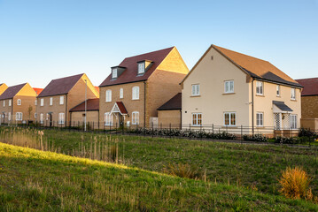 Modern  houses in a new suburban housing deveolpment under clear sky at sunset