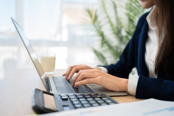 Business Task: A Focused Professional in a Corporate Setting engrossed in her work at her desk, demonstrating efficiency and commitment.