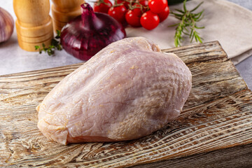 Raw chicken breast with bone and skin