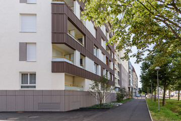 New apartment blocks along a tree lined street on a clear summer day