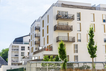 Two modern apartment buildings in a new development on a partly cloudy summer day