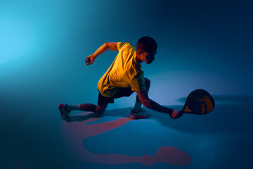 Naklejka premium Low padel defensive reach in immersive digital studio scene. Concept of movement breakdowns, sports analytics dashboards, reaction-speed features, coaching tools, fitness content creation.