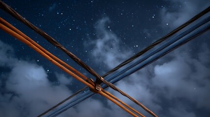 Dramatic overhead power lines crisscross the vast dark starry night sky illuminated by distant celestial bodies and atmospheric clouds