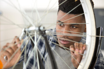 serviceman hand repair bicycle whee with screwdriver