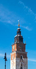 Town Hall Clock Tower on Main Square in the Old Town of Krakow. Old clock tower on a blue sky background