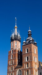 Basilica of St. Mary. Basilica with two towers of different shapes against a blue sky in front of the square