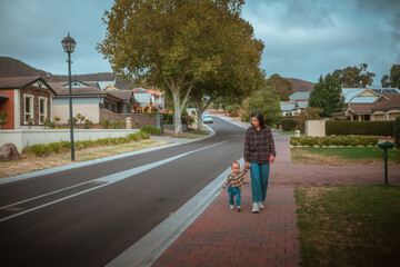 A peaceful and leisurely stroll taken by a mother and her child on a scenic street