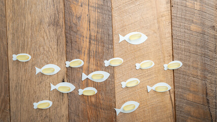 Fish oil soft gel capsule dietary supplements containing Omega 3 for heart health on a wooden table background.