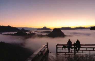Tourists stand gazing at the sea of ​​mist at Ban Jabo, Pang Mapha, Mae Hong Son, Thailand.