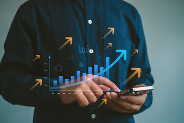 Business growth analytics concept with hand using smartphone and rising bar chart with upward arrows, representing performance tracking,digital marketing strategy,investment returns and revenue growth