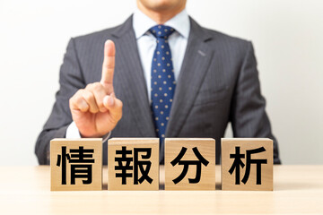 「情報分析」と書かれたブロックとビジネスマン