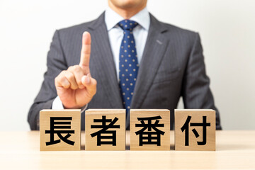 「長者番付」と書かれたブロックとビジネスマン