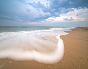 Soft sea foam flowing across wet sand under pale light creating a minimal seascape of balance rhythm and quiet tranquility