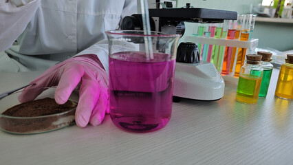 Scientist conducts chemistry experiment with colorful liquids and glassware in laboratory