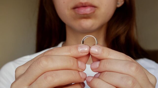 
A woman holds a wedding ring, a broken heart. An emotional journey through divorce and moving forward.