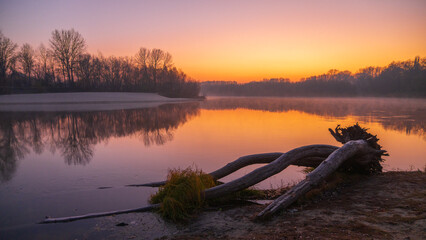 frosty  sunset on the lake and forest around the village