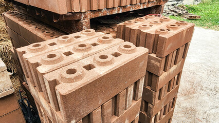 Stacked concrete bricks with hollow cores at a construction site, showing raw texture and earthy tones, representing building materials, industrial manufacturing, and infrastructure development.
