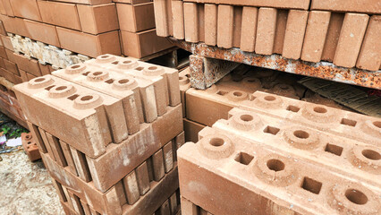 Stacked concrete bricks with hollow cores at a construction site, showing raw texture and earthy tones, representing building materials, industrial manufacturing, and infrastructure development.