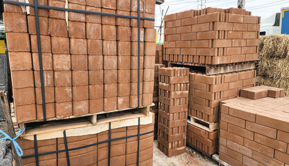 Stacked concrete bricks with hollow cores at a construction site, showing raw texture and earthy tones, representing building materials, industrial manufacturing, and infrastructure development.