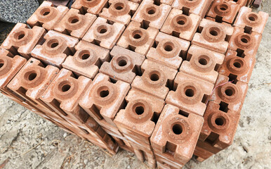 Stacked concrete bricks with hollow cores at a construction site, showing raw texture and earthy tones, representing building materials, industrial manufacturing, and infrastructure development.