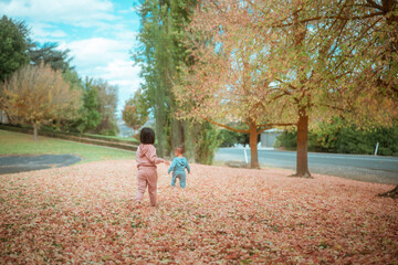 Two children joyfully running energetically through vibrant and colorful autumn foliage