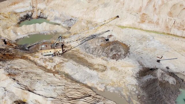Boom walking excavator digs ilmenite ore stratum in quarry