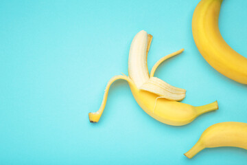 Open ripe banana on blue background. Space for text