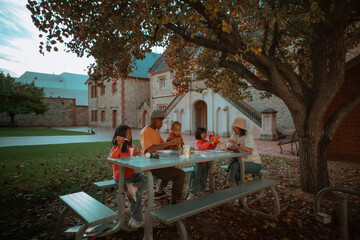 A cheerful family joyfully sharing a meal outdoors, surrounded by natures beauty in a warm environment