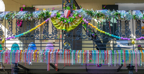 Mardi Gras beads on a balcony and carnival ornaments on a balcony in a street of the French Quarter, New Orleans, Louisiana