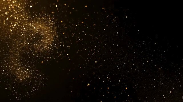 Golden sparkling particles shimmering on a dark background, creating an abstract and festive atmosphere.